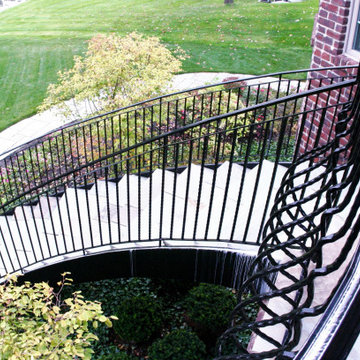 Curved Exterior Staircase with Wrought Iron Balcony Rail