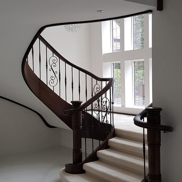 Curved Oak Stained staircase with wrought iron spindles