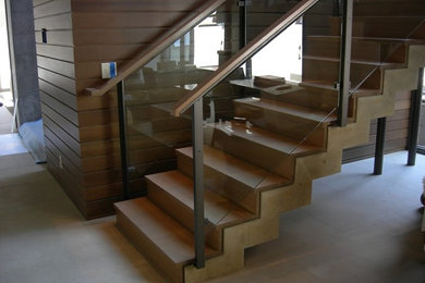 Imagen de escalera en L tradicional de tamaño medio con barandilla de madera, escalones de madera y contrahuellas de madera