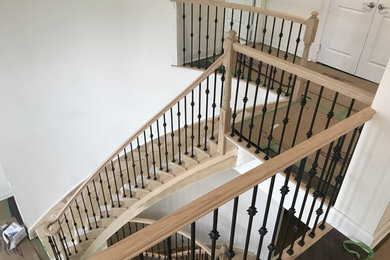 Ejemplo de escalera curva con barandilla de madera