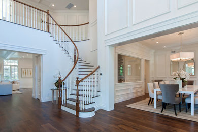 Medium sized classic wood curved staircase in Los Angeles with painted wood risers.