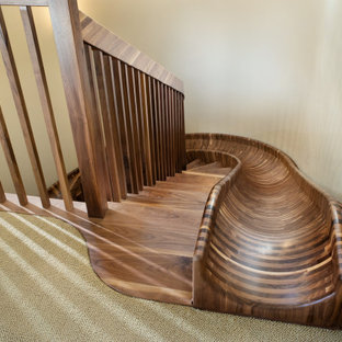 Esempio di un'ampia scala curva eclettica con pedata in legno, nessuna alzata e parapetto in legno