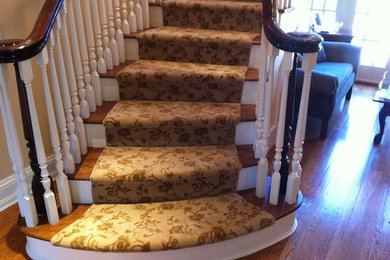 Inspiration for a mid-sized timeless wooden curved staircase remodel in New York with carpeted risers
