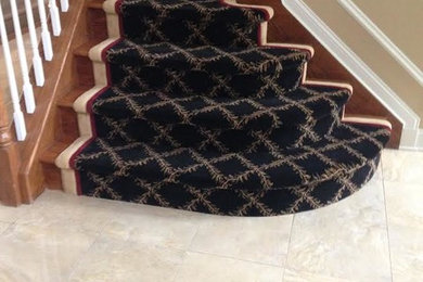 Mid-sized elegant carpeted curved wood railing staircase photo in Orange County with carpeted risers