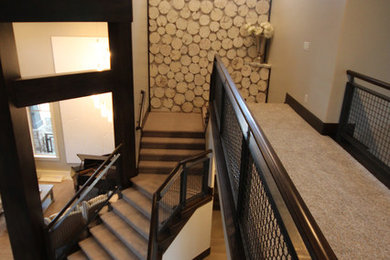 ソルトレイクシティにある高級な広いインダストリアルスタイルのおしゃれな折り返し階段 (カーペット張りの蹴込み板) の写真