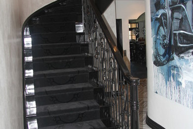 This is an example of a large modern carpeted curved staircase in New York with carpeted risers.