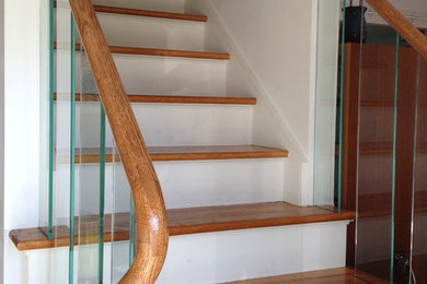 Exempel på en mellanstor modern rak trappa i trä, med sättsteg i målat trä och räcke i flera material