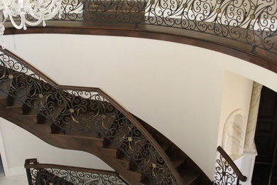 Diseño de escalera curva mediterránea grande con escalones de madera y contrahuellas de madera