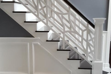 ニューヨークにある中くらいなトランジショナルスタイルのおしゃれなかね折れ階段 (フローリングの蹴込み板、木材の手すり) の写真