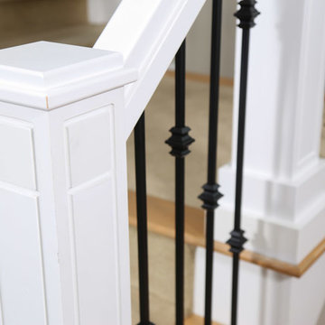 Custom staircase newel post and wrought iron balusters