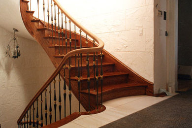 Diseño de escalera curva tradicional de tamaño medio con escalones de madera, contrahuellas de madera y barandilla de varios materiales