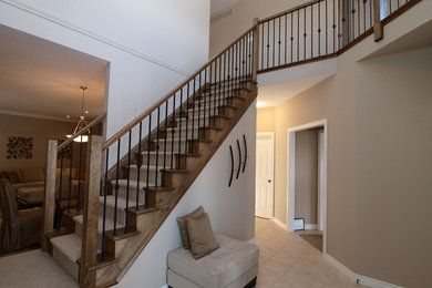 Ejemplo de escalera recta clásica renovada de tamaño medio con escalones enmoquetados, contrahuellas enmoquetadas y barandilla de metal