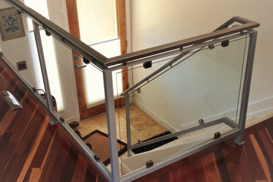 Diseño de escalera en L minimalista grande con barandilla de varios materiales