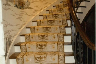 Modelo de escalera curva tradicional grande con escalones de madera y contrahuellas de madera pintada