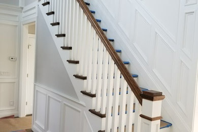 Diseño de escalera recta tradicional de tamaño medio con escalones de madera, contrahuellas de madera y barandilla de madera