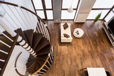 Imagen de escalera de caracol actual de tamaño medio sin contrahuella con escalones de madera y barandilla de madera