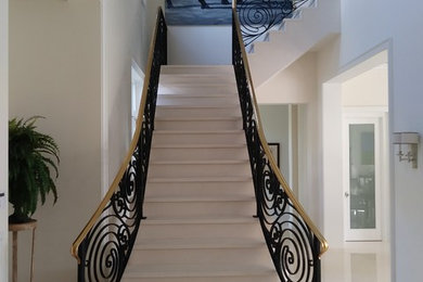 Staircase - large contemporary marble l-shaped metal railing staircase idea in Miami with marble risers