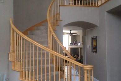 На фото: изогнутая деревянная лестница в классическом стиле с деревянными ступенями с