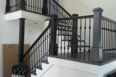 Large elegant wooden u-shaped wood railing staircase photo in New York with wooden risers