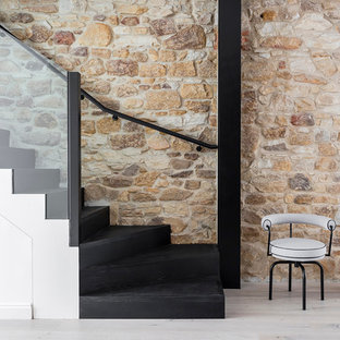 Photo of a contemporary wood curved staircase in Sydney with wood risers and glass railing.