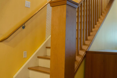 Ejemplo de escalera recta de estilo americano pequeña con escalones de madera y contrahuellas de madera pintada
