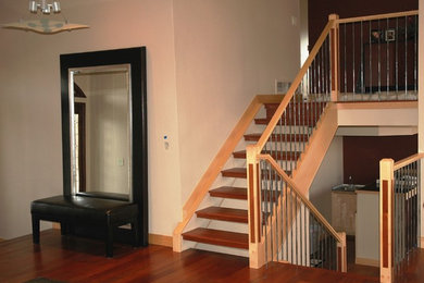 Foto de escalera contemporánea con escalones de madera, contrahuellas de madera y barandilla de varios materiales