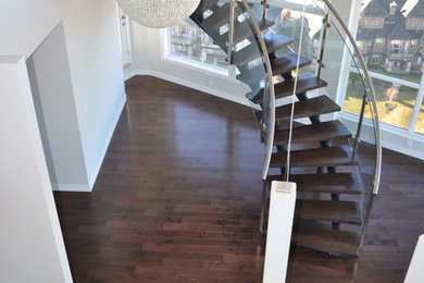 Photo of a medium sized modern wood curved staircase in Edmonton with open risers.