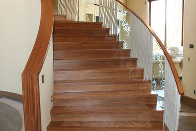 Example of a minimalist wooden curved staircase design in Las Vegas with wooden risers