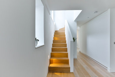 Design ideas for a medium sized contemporary wood l-shaped staircase in London with wood risers.