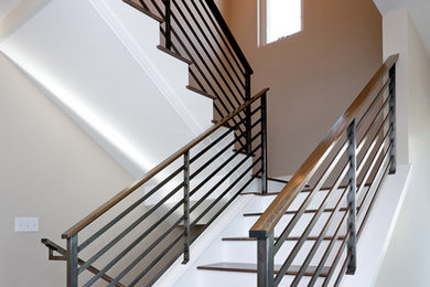 Ejemplo de escalera contemporánea con escalones de madera y barandilla de varios materiales