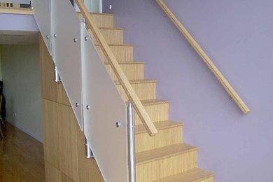 Ejemplo de escalera recta minimalista pequeña con escalones de madera, contrahuellas de madera y barandilla de varios materiales