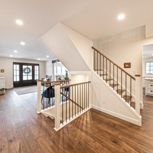 Foto di una grande scala a "L" stile americano con pedata in legno, alzata in legno e parapetto in materiali misti