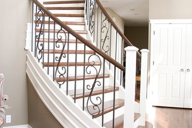 Exemple d'un grand escalier peint courbe chic avec des marches en bois.