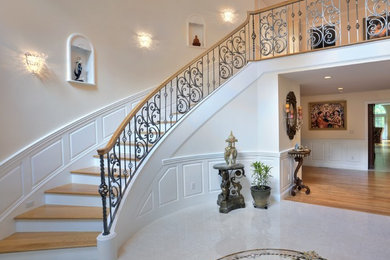 Inspiration for a large timeless wooden curved staircase remodel in Boston with painted risers