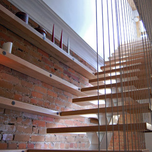Aménagement d'un escalier sans contremarche scandinave en L avec des marches en bois et un garde-corps en métal.