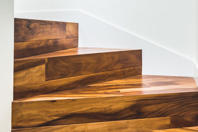 Diseño de escalera curva bohemia con escalones de madera y contrahuellas de madera