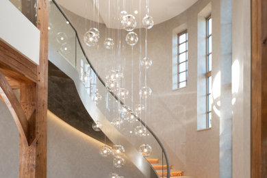 Ejemplo de escalera curva actual con escalones de metal y barandilla de vidrio
