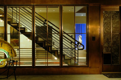 デンバーにある広いインダストリアルスタイルのおしゃれな直階段 (フローリングの蹴込み板、混合材の手すり) の写真