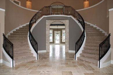 Imagen de escalera curva clásica grande con escalones enmoquetados, contrahuellas enmoquetadas y barandilla de metal