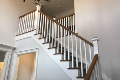 Ejemplo de escalera en L clásica de tamaño medio con escalones de madera y contrahuellas de madera pintada
