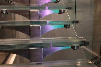 Medium sized contemporary glass u-shaped mixed railing staircase in Toronto with open risers.