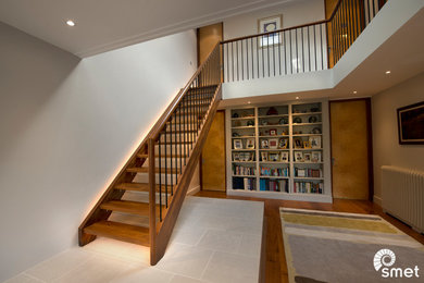 Diseño de escalera recta vintage con escalones de madera, contrahuellas de vidrio y barandilla de metal