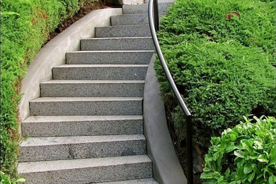 Idée de décoration pour un grand escalier courbe tradition en béton avec des contremarches en béton.