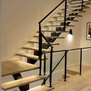 Staircase - large modern wooden l-shaped glass railing staircase idea in Chicago with metal risers
