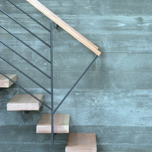 Esempio di una scala sospesa minimalista con pedata in legno