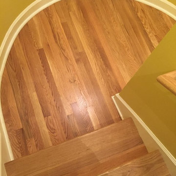 Finish-on-site oak natural staircase conversion with semicircular landing