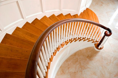 Diseño de escalera curva tradicional de tamaño medio con escalones de madera pintada y contrahuellas de madera pintada