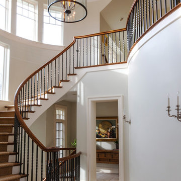 Floating Curved Millmade Staircase with Iron Balusters and Wood Railing