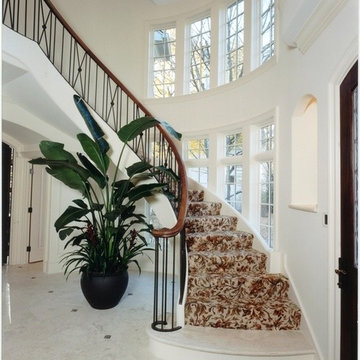 Floating Curved Staircase with Walnut Railing and Iron Balusters