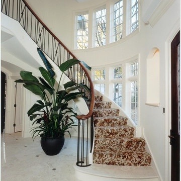 Floating Curved Staircase with Walnut Railing and Iron Balusters